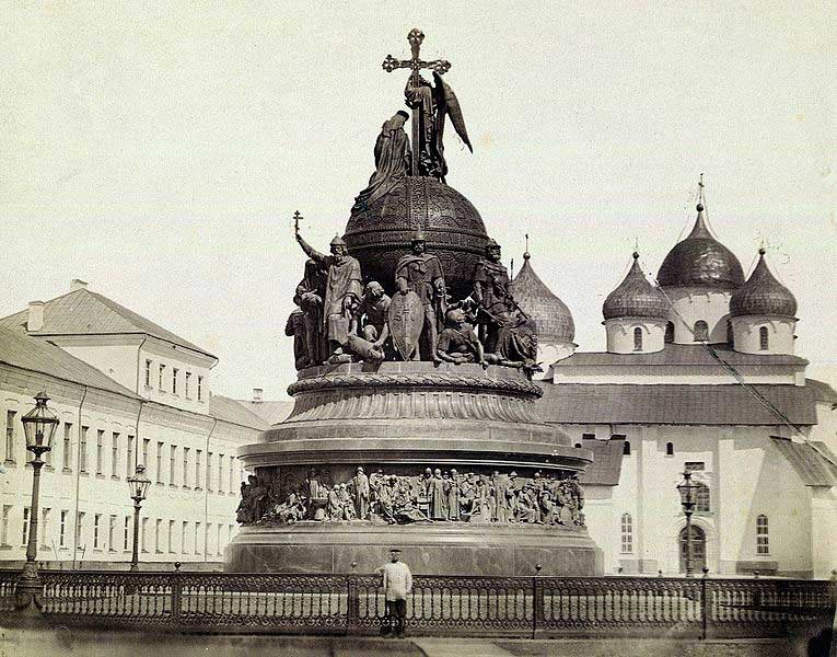 Памятник Тысячелетие России, возведённый в Новгороде в 1862. В центре композиции изображён Рюрик с щитом, слева от него — Владимир Креститель Памятник Тысячелетие России, возведённый в Новгороде в 1862. В центре композиции изображён Рюрик с щитом, слева от него — Владимир Креститель